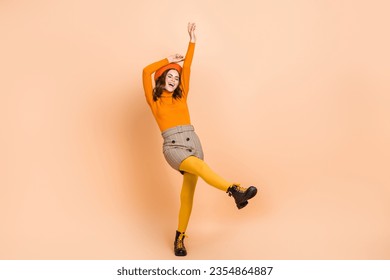 Full length photo of carefree cheerful overjoyed adorable lady wear orange clothes have fun empty space isolated on beige color background - Powered by Shutterstock