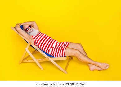 Full length photo of carefree pensioner lying sunbed chilling on the beach wear striped swimwear isolated over yellow color background - Powered by Shutterstock