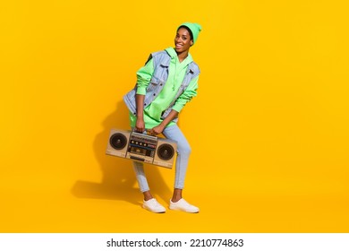 Full Length Photo Of Carefree Positive Girl Carry Vintage Boom Box Free Time Isolated On Yellow Color Background