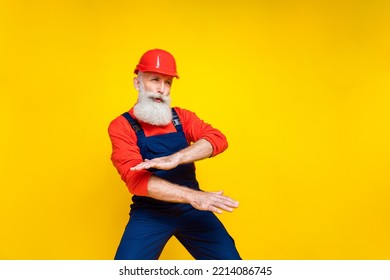 Full Length Photo Of Carefree Senior Engineer With White Beard Red Helmet Dancing Look Empty Space Isolated On Yellow Color Background