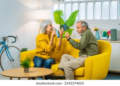 Full length photo of a caucasian senior couple arguing and discussing sitting on the sofa - Powered by Shutterstock