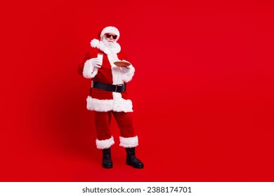 Full length photo of charismatic santa hands hold christmas glass mil cookie plate empty space isolated on red color background