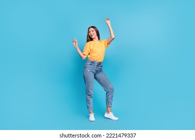 Full length photo of charming excited lady wear yellow t-shirt dancing smiling having fun isolated blue color background