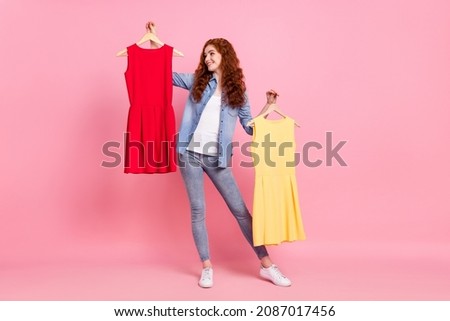 Full length photo of charming happy positive young woman hold hands dress choose isolated on pink color background