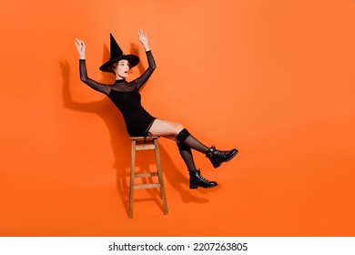 Full Length Photo Of Charming Lady Sit Chair Lose Balance Fall Dressed Trendy Black Halloween Garment Isolated On Orange Color Background