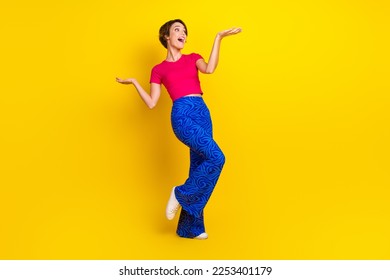 Full length photo of charming pretty lady wear stylish clothes cool offer compare products empty space isolated on yellow color background - Shutterstock ID 2253401179