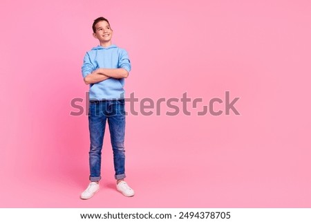 Full length photo of charming teen boy crossed hands look empty space dressed stylish blue garment isolated on pink color background