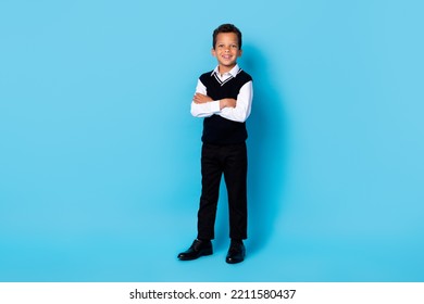 Full length photo of cheerful charming small boy wear black waistcoat smiling arms crossed isolated blue color background - Powered by Shutterstock