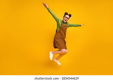 Full length photo of cheerful dreamy girl nerd high school student jump hold hand fly like bird wear green sweater skirt overall gumshoes isolated over bright shine color background - Shutterstock ID 1834544629