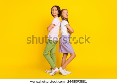 Full length photo of cheerful dreamy friends wear casual outfits arms crossed looking emtpy space isolated yellow color background