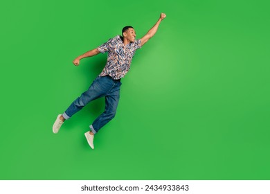 Full length photo of cheerful glad funky courageous man raise hand fly air empty space isolated on green color background - Powered by Shutterstock