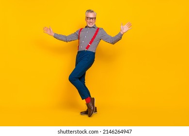 Full length photo of cheerful good mood grandpa dancing in nightclub wear suspenders isolated on yellow color background