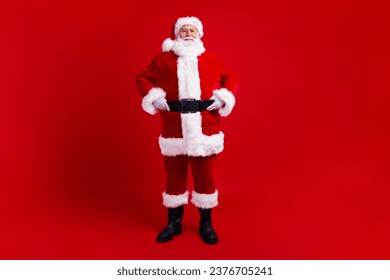Full length photo of cheerful good mood santa claus winter magic season new year time isolated on red color background