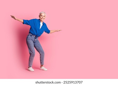 Full length photo of cheerful pretty lady dressed blue shirt riding skateboard empty space isolated pink color background - Powered by Shutterstock