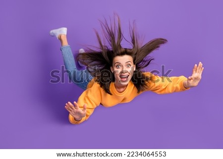 Full length photo of cheerful pretty lady rejoice can fly halloween party wear orange trendy sweater isolated on purple color background