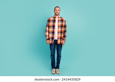 Full length photo of confident stylish good mood man wear flannel shirt jeans pants standing isolated on turquoise color background