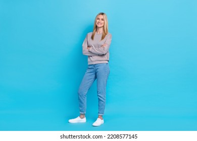 Full Length Photo Of Confident Sweet Lady Wear Grey Sweatshirt Standing Arms Folded Smiling Isolated Blue Color Background