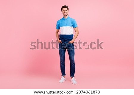 Full length photo of cool brunet young guy stand wear polo jeans sneakers isolated on pink background