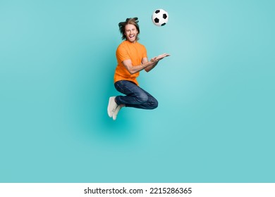 Full Length Photo Of Cool Cheerful Guy Dressed Orange T-shirt Jumping High Throwing Football Ball Isolated Teal Color Background