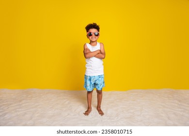 Full length photo of cool confident small boy wear white shirt dark eyewear arms crossed enjoying rest isolated yellow color background - Powered by Shutterstock