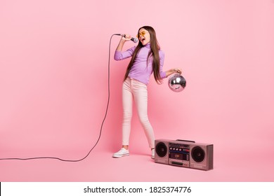 Full Length Photo Of Cool Small Kid Girl Sing Song Mic Hold Disco Ball With Boom Box Isolated Over Pastel Color Background