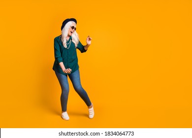 Full Length Photo Of Crazy Granny Lady Music Lover Senior Party Cool Look Dance Youth Moves Wear Green Shirt Sun Specs Necklace Retro Cap Shoes Isolated Yellow Color Background