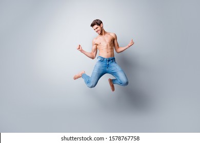 Full Length Photo Of Crazy Macho Man Guy Jumping High Topless Torso Metrosexual Hot Body Competitive Mood Celebrating Successful Competition Wear Jeans Isolated Grey Background