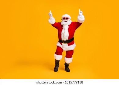 Full length photo of crazy santa claus with grey beard listen wireless modern headset x-mas christmas music dance party wear sunglass cap isolated bright shine color background - Powered by Shutterstock