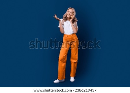 Full length photo of cute adorable girl wear trendy clothes speak phone look up empty space offer isolated on dark blue color background