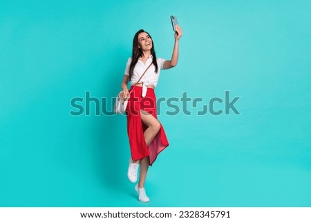 Full length photo of cute lady dressed crop top purse recording video vlog apple samsung iphone isolated turquoise color background