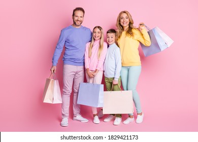 Full Length Photo Of Dream Family Mom Dad Little Kids Hold Bags From Shopping Center Isolated On Pink Pastel Color Background