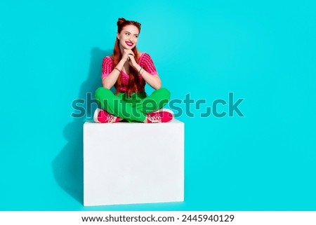 Full length photo of dreamy cute lady dressed pink knitted shirt sitting platform looking empty space isolated blue color background