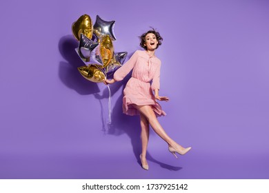Full Length Photo Of Energetic Candid Girl Hold Many Balloons Enjoy Prom Graduation Party Wear Polka-dot Clothes Footwear Isolated Over Purple Color Background