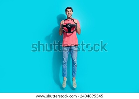 Full length photo of excited funky man wear pink t-shirt jumping high riding automobile isolated blue color background