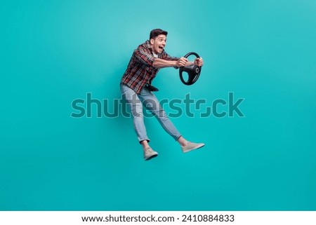 Full length photo of excited funny man dressed plaid shirt jumping high riding car isolated turquoise color background