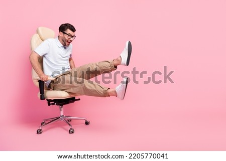Full length photo of excited guy look copyspace fast ride chair game isolated on pastel color background