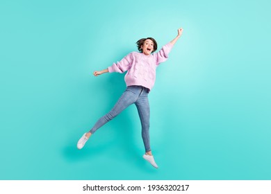 Full length photo of excited pretty young lady dressed purple pullover jumping catching isolated teal color background - Shutterstock ID 1936320217
