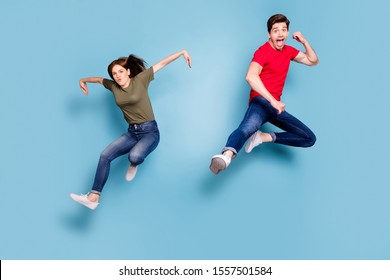 Full length photo of funky funny crazy two people students sportive team man woman jump practice fighting sport exercise kick hands wear casual style outfit isolated blue color background