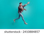 Full length photo of funky good mood man dressed plaid shirt jumping high catching arms empty space isolated turquoise color background