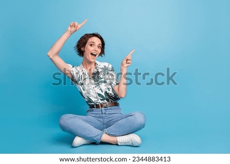 Full length photo of funky shocked woman dressed print shirt showing two fingers empty space isolated blue color background