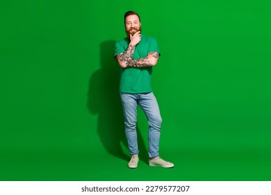 Full length photo of funky thoughtful guy dressed t-shirt arm chin smiling isolated green color background - Shutterstock ID 2279577207