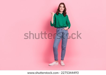 Full length photo of funny cute lady dressed green blouse pointing thumb emtpy space isolated pink color background