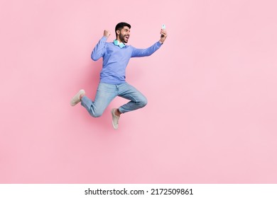 Full Length Photo Of Funny Lucky Arabian Man Wear Long Sleeve Shirt Blogging Gadget Jumping Running Isolated Pink Color Background