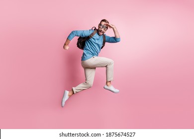 Full length photo of funny man dressed sweater rucksack jumping parachute looking far away isolated pink color background