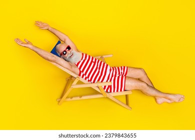 Full length photo of funny pensioner wearing striped swimwear chilling lying sunbed at the beach isolated on yellow color background - Powered by Shutterstock