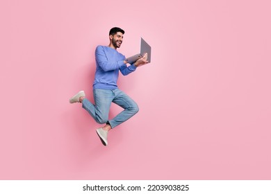 Full length photo of funny pretty guy dressed blue pullover jumping high typing modern device isolated pink color background - Shutterstock ID 2203903825