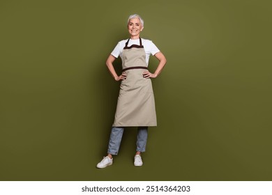 Full length photo of good mood attractive lady dressed apron preparing drinks smiling empty space isolated green color background - Powered by Shutterstock