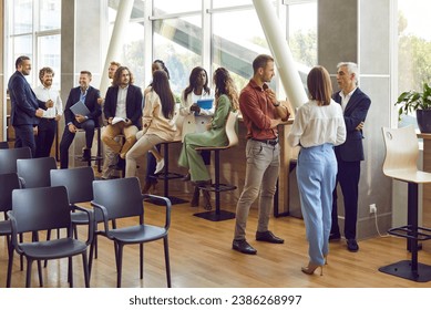 Full length photo of a group of diverse business people men and women chatting after meeting. Company employees or group of staff talking in modern office or conference room discussing work project. - Powered by Shutterstock