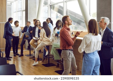 Full length photo of a group of diverse business people men and women chatting after meeting. Company employees or group of staff talking in modern office or conference room discussing work project. - Powered by Shutterstock