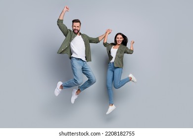 Full length photo of guy lady delighted bargain jump up raise fists scream yes isolated grey color background